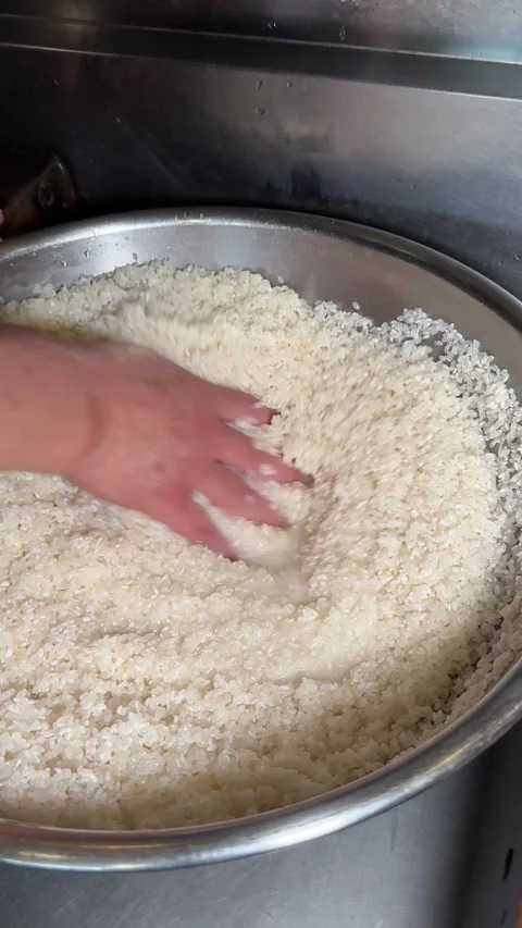Chef Washing Rice By Hand In A Stainless Bowl, Japanese Izakaya, Vertical 4K Stock Footage 344856392