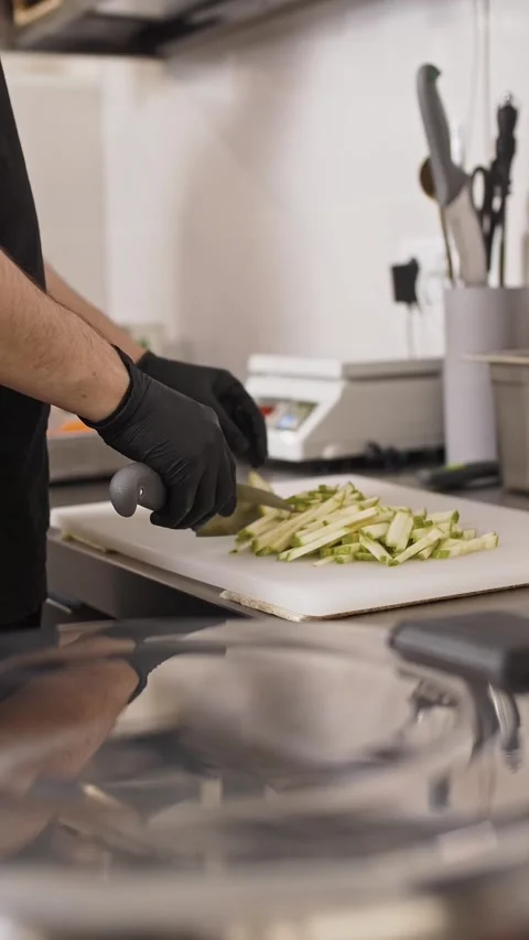 Chef wearing black gloves chops zucchini and zucchini Stock Footage 282784294