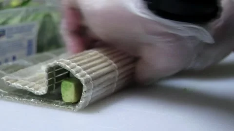 Chef Wearing Black Gloves Rolls Avocado Sushi in Video Stock Footage 285248489