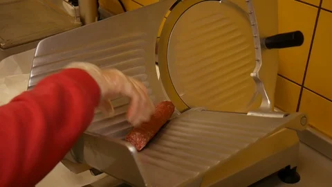 Chef wearing rubber glove using ham slicer machine Stock Footage 128643437