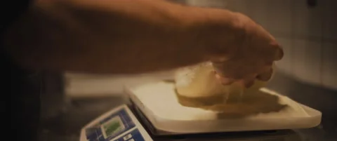 Chef weighing pizza dough on a scale in restaurant kitchen. Close up, slow mo Stock Footage 146918304