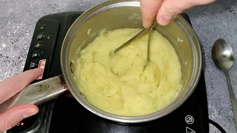 The chef is whipping mashed potatoes with a potato masher Stock Footage 230015387