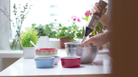 The chef whips food on the kitchen table with a blender. 4K. Stock Footage 153240016