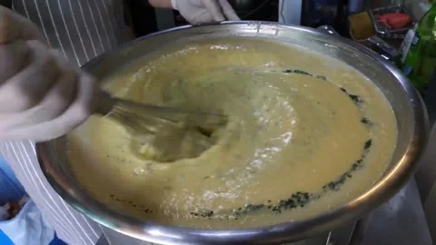 Chef Whisking Herbs into Large Pot of Thick Soup Base Video stock 343587399