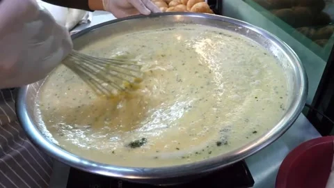 Chef Whisking Thick Creamy Yellow Soup Batter in Metal Bowl Video stock 343587429