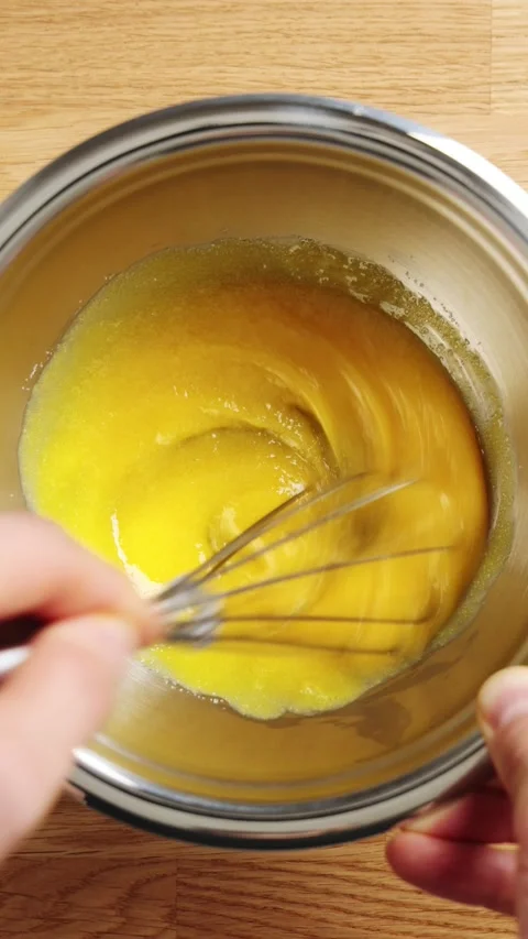 Chef whisks egg yolk and sugar in metal bowl, timelapse. Stock Footage 345273669