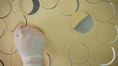 Chef in white gloves cuts circles out of dough Stock Footage 155203048