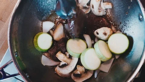The chef in white gloves preparing meat with mushrooms and zucchini Stock Footage 73212835