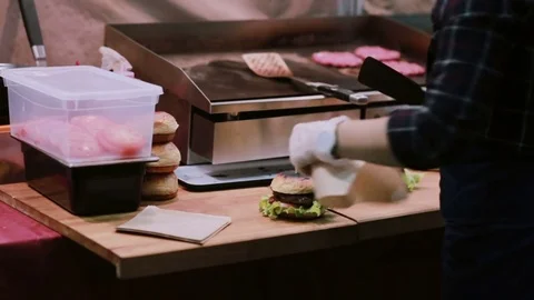 A chef in white gloves putting every burger into package for the customers to be Video stock 72416854