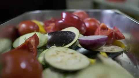 A chef in white gloves salts vegetables cut into bushes in a large container Stock Footage 245871523