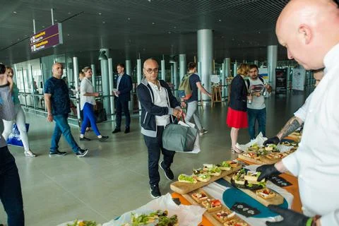 Chef in white uniform serving snacks on table for degustation in Lviv airport Stock Photos