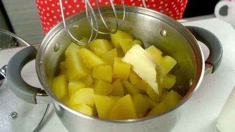 Chef woman adding butter and whisking in saucepan cooking mashed potatoes. Stock Footage 312402846