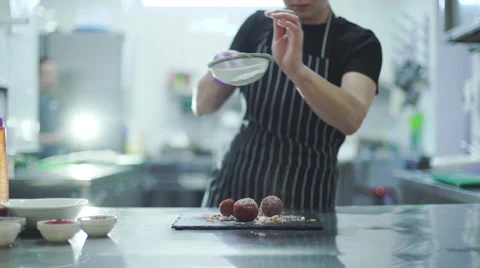 Chef woman is finishing sweet dessert at commercial kitchen in a restaurant Stock Footage