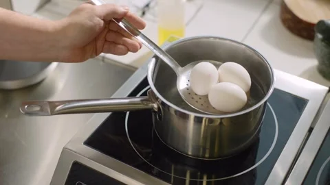 The chef is at work. Cooking boiled eggs for salad or toast. Stock Footage 277131483