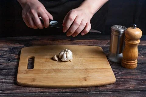 Chef at work. Cook's hands are tearing a knife over garlic. Preparing the ing Stock Photos