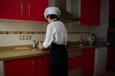 Chef At Work In A Modern Kitchen Mixing Batter In A Stainless Bowl Stock Photos