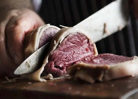 A chef working on slicing a piece of steak food photography recipe idea Stock Photos