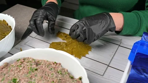 Chef wrapping dolma with minced meat using grape leaves Stock Footage 295039746