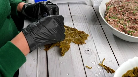 Chef wrapping dolma with minced meat using grape leaves Vidéo 295039956