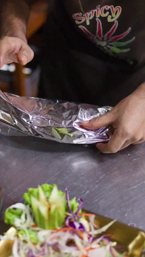 Chef Wrapping Fresh Naan Flatbread in Aluminum Foil at Restaurant Stock Footage 345784057