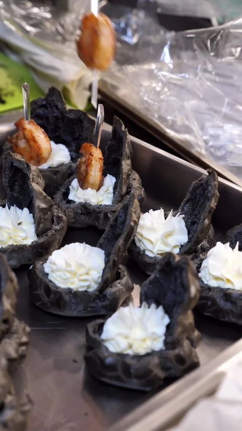 Chef&amp;#039;s hand placing a grilled shrimp on a gourmet black profiterole. Stock Footage 342149957
