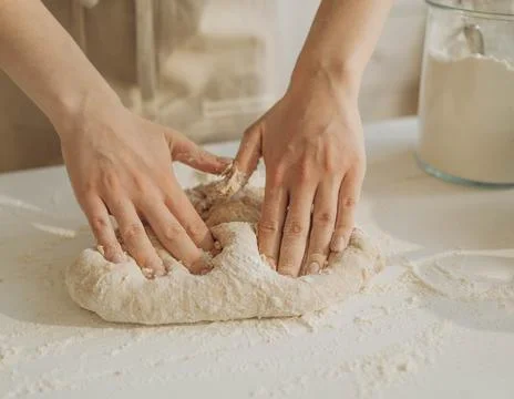 Chef&amp;#039;s Hands Kneading Bread Dough on a Floured Worktop Stock Photos