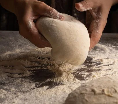 Chef&amp;#039;s Hands Kneading Bread Dough on a Floured Worktop Stock Photos