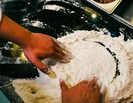 Chef&amp;#039;s Hands Kneading Bread Dough on a Floured Worktop Stock Photos