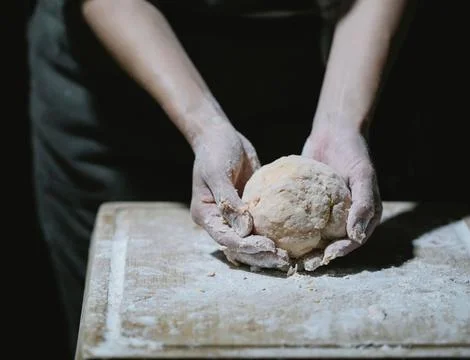 Chef&amp;#039;s Hands Kneading Bread Dough on a Floured Worktop Stock Photos
