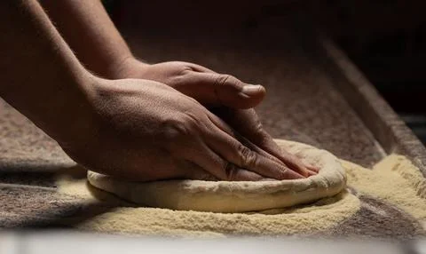 Chef&amp;#039;s Hands Kneading Bread Dough on a Floured Worktop Stock Photos