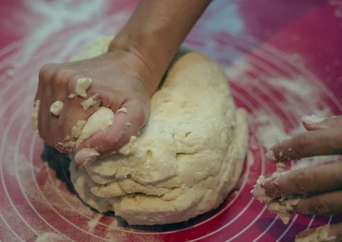 Chef&amp;#039;s Hands Kneading Bread Dough on a Floured Worktop Stock Photos