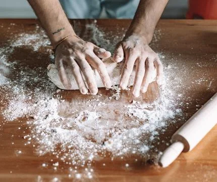 Chef&amp;#039;s Hands Kneading Bread Dough on a Floured Worktop Stock Photos
