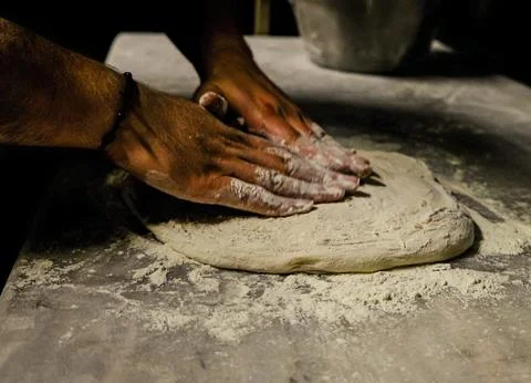 Chef&amp;#039;s Hands Kneading Bread Dough on a Floured Worktop Stock Photos
