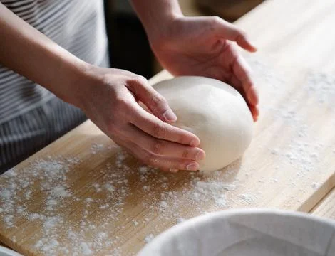 Chef&amp;#039;s Hands Kneading Bread Dough on a Floured Worktop Stock Photos