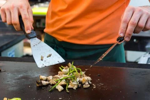 Cheff preparing traditional Mediterranean squid dish on a hot grill. Stock Photos