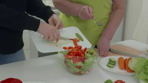 Chefs adding chopped bell peppers to a fresh salad Stock Footage 321041775