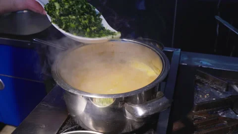 A chef's adding cutted cabbage to soup Stock Footage 146850833