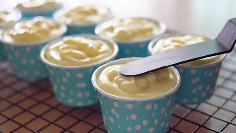 Chefs are using a spatula spread cream cheese on a blue cupcake. Stock Footage 104086196