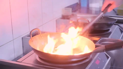 Chefs cooking preparing a dish in wok Stock Footage 236056208