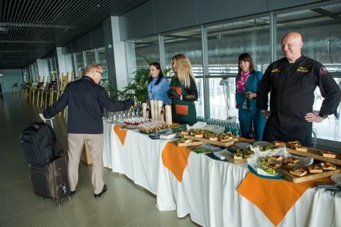 Chefs in different uniforms serving snacks on table for degustation in Lviv a 写真素材