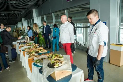 Chefs in different uniforms serving snacks on table for degustation in Lviv Foto stock