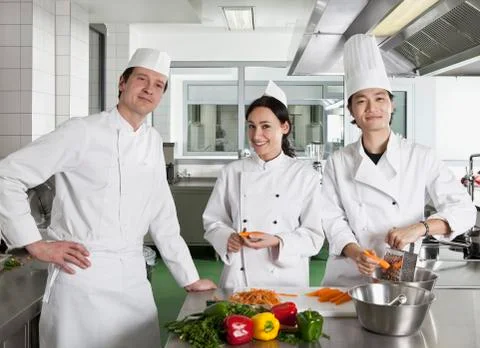 Chefs doing prep work in a commercial kitchen Stock Photos