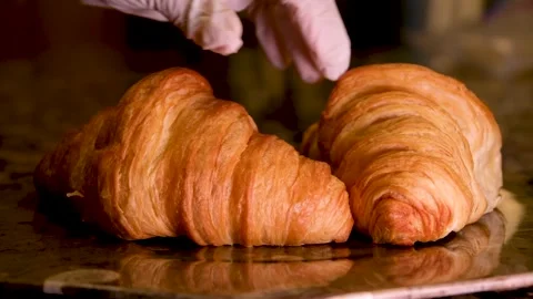 Chef's gloved hands touching two croissants throwing squeezing examining raising Stock Footage 243252993