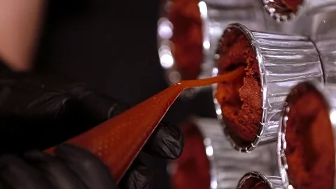 Chefs in gloves pour boiled condensed milk into a muffin, vertical vide Stock Footage 297623906