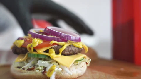 The chef's hand in black rubber gloves takes the second part of the bun and Stock Footage 132029657