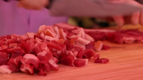 A chef's hand cuts meat with a knife Видео 303539800