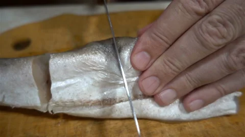 The chef's hand cuts raw fish with a knife in slow motion Stock-Footage 138294784
