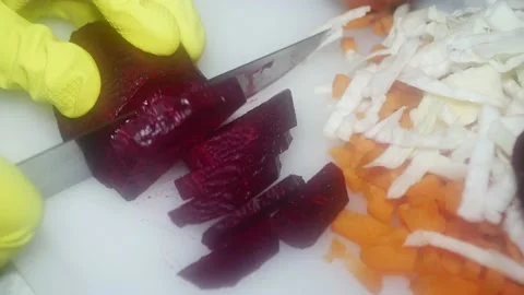 The chef's hand cuts red beets with a knife on a cutting board for cooking d 스톡 동영상 231326152
