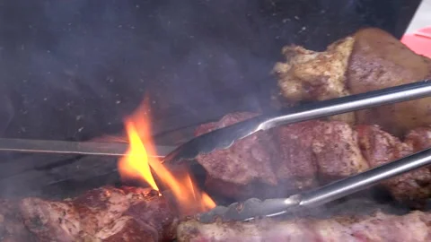 Chef's hand flips the meat for even cooking Stock Footage 133251652