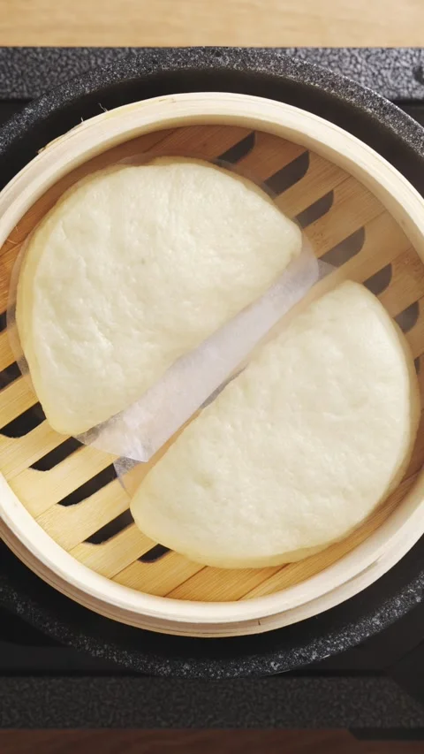 Chef’s hand opens bamboo lid, showing hot bao buns. Stock Footage 341951463